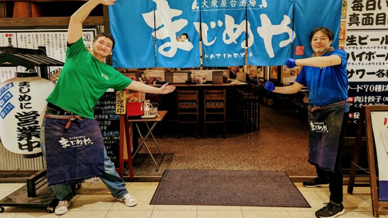 稲わら家で働く人の写真1枚目